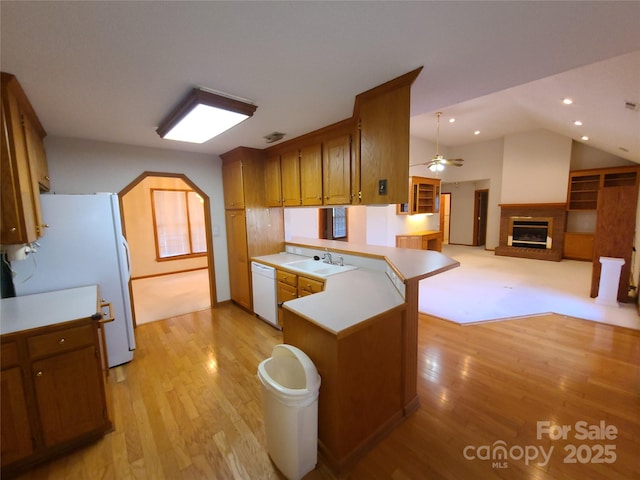 110 Kimberly Ln, Kings Mountain, NC 28086 - kitchen featuring white appliances, a peninsula, a glass covered fireplace, light wood-type flooring, and brown cabinetry