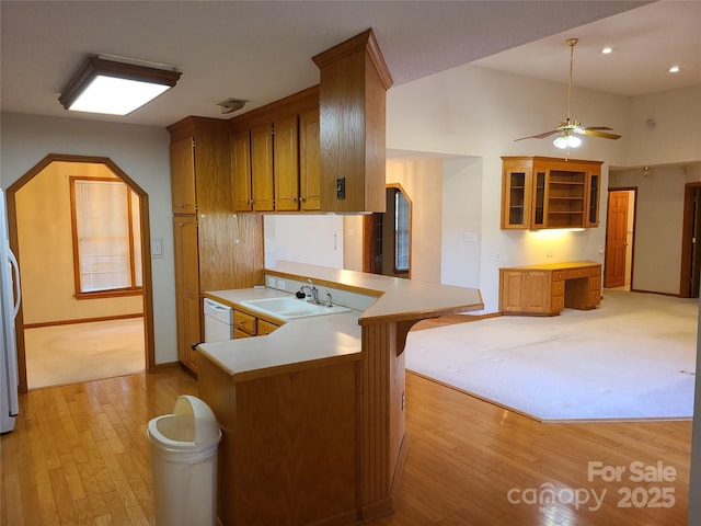 110 Kimberly Ln, Kings Mountain, NC 28086 - kitchen with light wood-style floors, brown cabinetry, white appliances, a peninsula, and glass insert cabinets