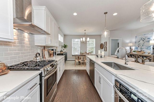 122 Wesser St Unit 14, Davidson, NC 28036 - kitchen featuring appliances with stainless steel finishes, wall chimney range hood, white cabinets, dark wood-style flooring, and tasteful backsplash
