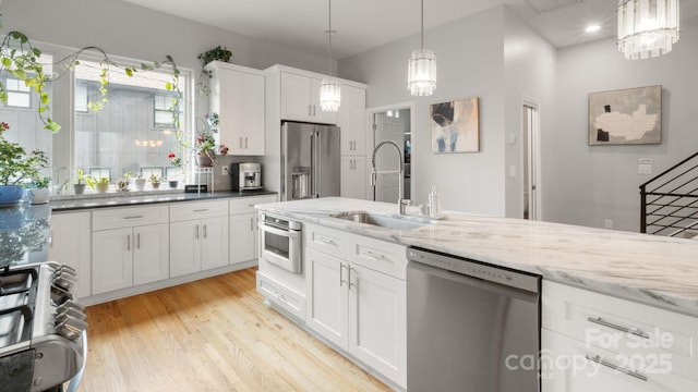 1011 Westbrook Dr Unit A, Charlotte, NC 28202 - kitchen featuring stainless steel appliances, light wood finished floors, white cabinets, and decorative light fixtures