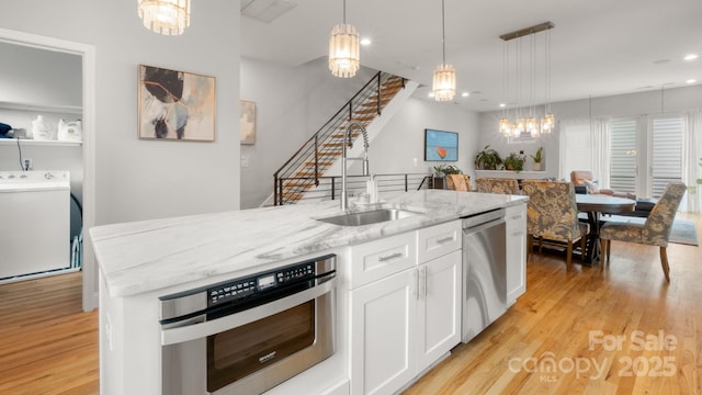 1011 Westbrook Dr Unit A, Charlotte, NC 28202 - kitchen featuring dishwasher, wall oven, a chandelier, light wood finished floors, and white cabinets
