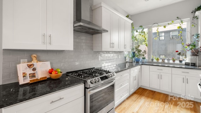 1011 Westbrook Dr Unit A, Charlotte, NC 28202 - kitchen with stainless steel gas range, wall chimney exhaust hood, white cabinetry, decorative backsplash, and light wood-type flooring