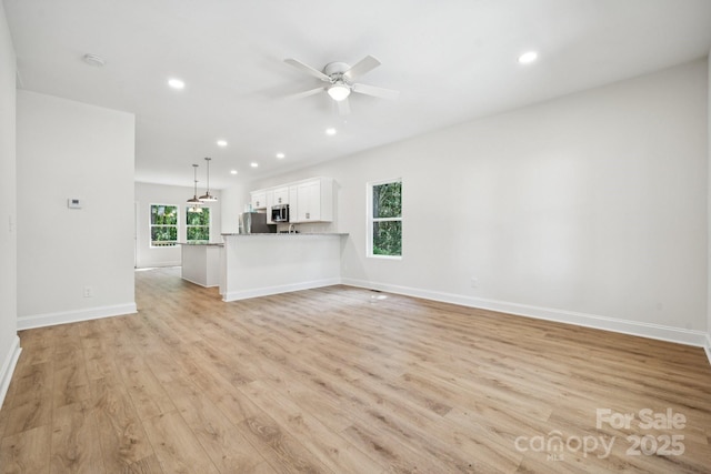54 Reed St NE, Concord, NC 28025 - unfurnished living room featuring light wood-style floors, ceiling fan, and recessed lighting