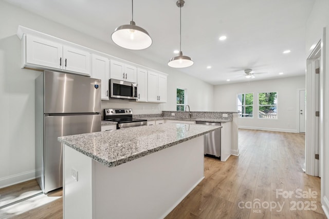 54 Reed St NE, Concord, NC 28025 - kitchen featuring stainless steel appliances, a ceiling fan, light wood-style flooring, a peninsula, and a center island