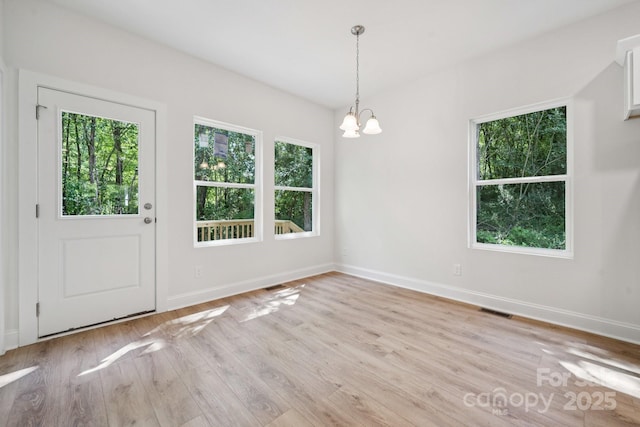 54 Reed St NE, Concord, NC 28025 - unfurnished dining area with healthy amount of natural light, a chandelier, and light wood-type flooring