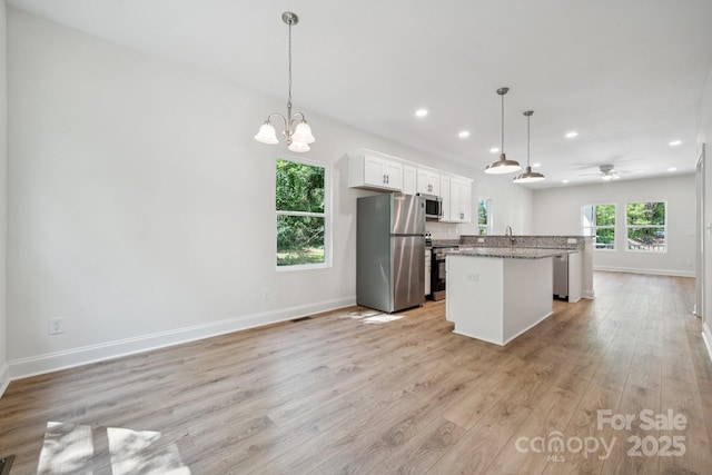54 Reed St NE, Concord, NC 28025 - kitchen with appliances with stainless steel finishes, a center island with sink, recessed lighting, light wood-type flooring, and white cabinets