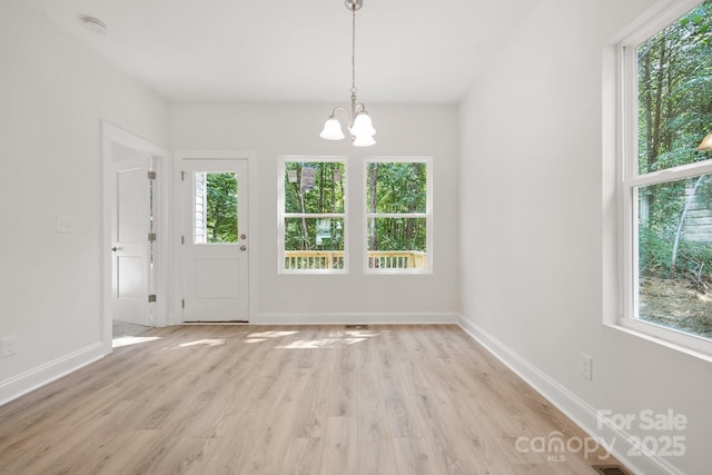 54 Reed St NE, Concord, NC 28025 - unfurnished dining area with a chandelier, healthy amount of natural light, and light wood-style floors