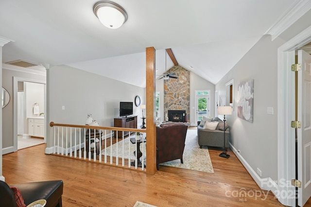 4824 Waxhaw Farms Rd, Waxhaw, NC 28173 - living area with a ceiling fan, wood finished floors, a stone fireplace, crown molding, and vaulted ceiling