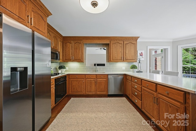 4824 Waxhaw Farms Rd, Waxhaw, NC 28173 - kitchen with appliances with stainless steel finishes, ornamental molding, a peninsula, light countertops, and tasteful backsplash
