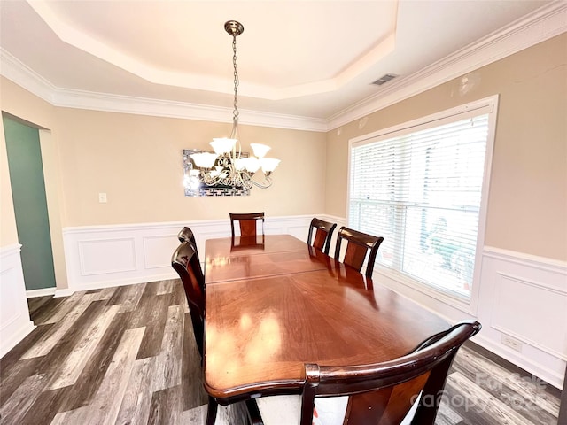 9792 Ravenscroft Ln NW, Concord, NC 28027 - dining space with a chandelier, a tray ceiling, dark wood finished floors, wainscoting, and a decorative wall