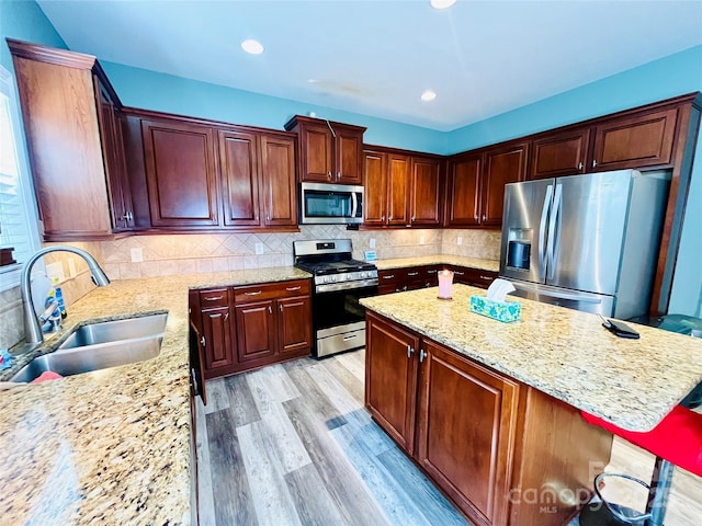 9792 Ravenscroft Ln NW, Concord, NC 28027 - kitchen featuring stainless steel appliances, a center island, light wood-style floors, light stone countertops, and recessed lighting