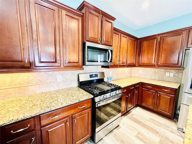 9792 Ravenscroft Ln NW, Concord, NC 28027 - kitchen with stainless steel appliances, light stone countertops, backsplash, and light wood-type flooring