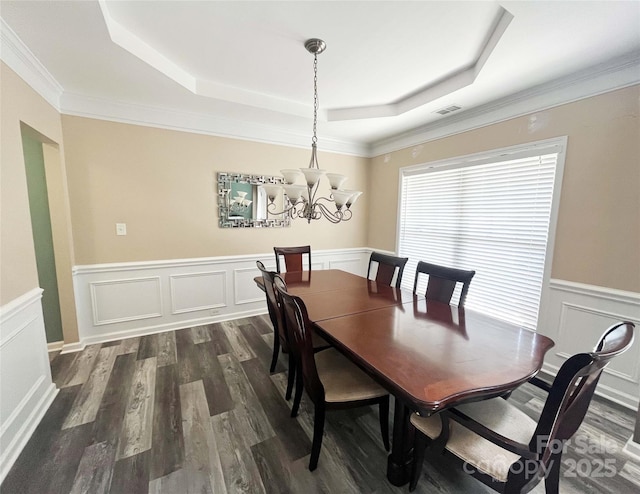 9792 Ravenscroft Ln NW, Concord, NC 28027 - dining room featuring a raised ceiling, dark wood-style flooring, a decorative wall, a chandelier, and wainscoting