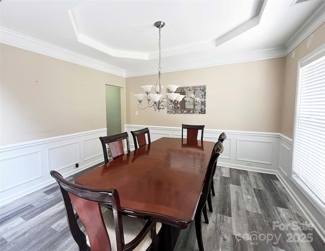 9792 Ravenscroft Ln NW, Concord, NC 28027 - dining room with a tray ceiling, dark wood-style flooring, a chandelier, wainscoting, and a decorative wall