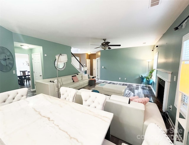 9792 Ravenscroft Ln NW, Concord, NC 28027 - living room with stairway, ceiling fan, wood finished floors, and a fireplace with raised hearth