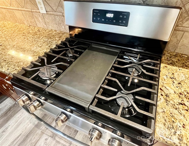 9792 Ravenscroft Ln NW, Concord, NC 28027 - kitchen view of gas range, wood finished floors, and backsplash