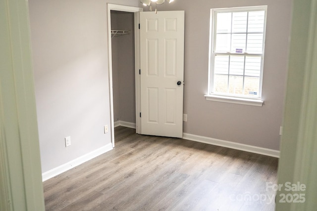 830 Mcarthur Ave, Charlotte, NC 28206 - unfurnished bedroom with wood finished floors, a closet, and a walk in closet