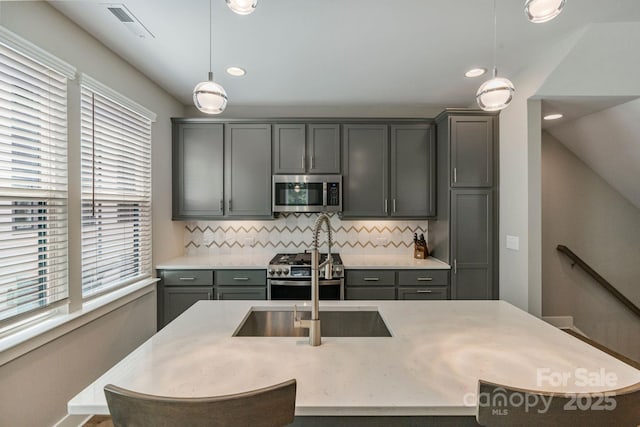 2969 Simpson Dr, Charlotte, NC 28205 - kitchen with appliances with stainless steel finishes, backsplash, hanging light fixtures, a center island with sink, and recessed lighting