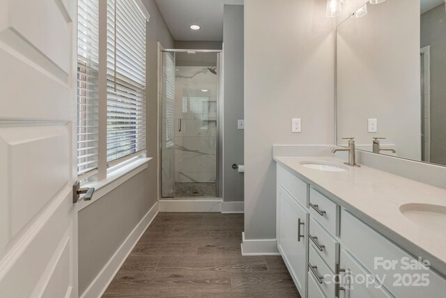 2969 Simpson Dr, Charlotte, NC 28205 - bathroom with double vanity, a stall shower, wood finished floors, and recessed lighting