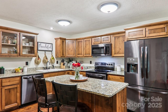 2171 Black Rock Rd, Cherokee, NC 28719 - kitchen featuring stainless steel appliances, a textured ceiling, a kitchen bar, brown cabinets, and a center island