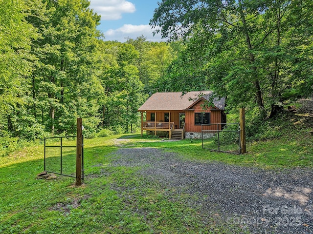 2171 Black Rock Rd, Cherokee, NC 28719 - chalet / cabin with a wooded view, a front yard, a deck, board and batten siding, and a shingled roof