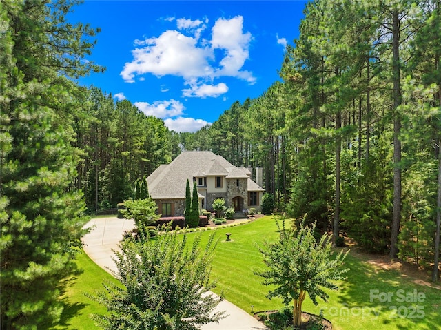 168 Blue Ridge Trl, Mooresville, NC 28117 - view of front facade featuring stone siding, a wooded view, a front yard, and driveway