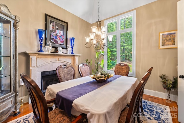 168 Blue Ridge Trl, Mooresville, NC 28117 - dining area featuring a chandelier, wood finished floors, a tiled fireplace, and lofted ceiling