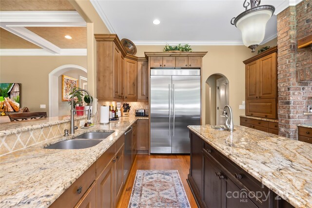 168 Blue Ridge Trl, Mooresville, NC 28117 - kitchen featuring appliances with stainless steel finishes, wood finished floors, light stone countertops, crown molding, and decorative backsplash
