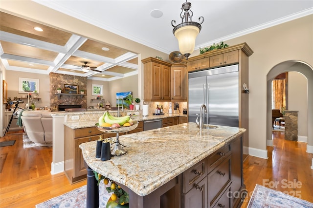 168 Blue Ridge Trl, Mooresville, NC 28117 - kitchen featuring stainless steel appliances, arched walkways, ceiling fan, open floor plan, and a fireplace