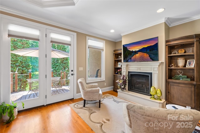 168 Blue Ridge Trl, Mooresville, NC 28117 - living room featuring wood finished floors, a glass covered fireplace, crown molding, and recessed lighting