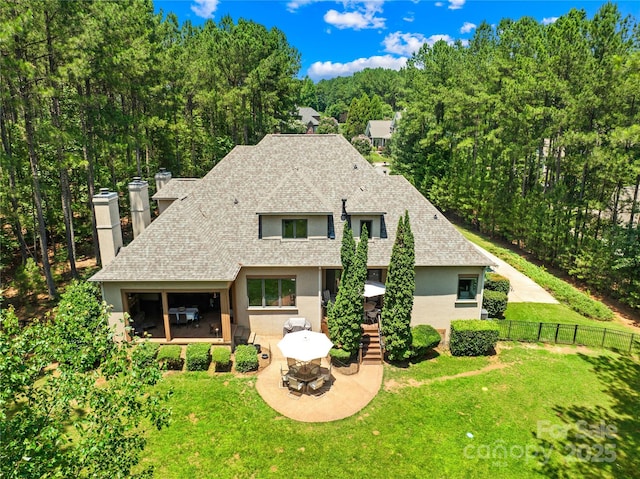168 Blue Ridge Trl, Mooresville, NC 28117 - back of house with roof with shingles, a chimney, stucco siding, and a patio