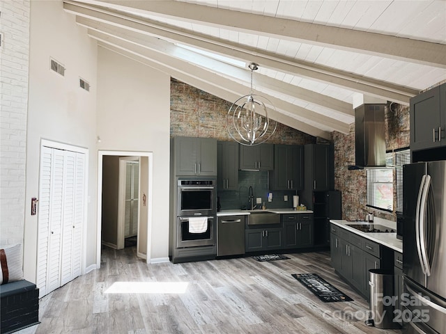 5017 Celeste Ct, Charlotte, NC 27609 - kitchen featuring appliances with stainless steel finishes, wall chimney exhaust hood, light countertops, a chandelier, and high vaulted ceiling