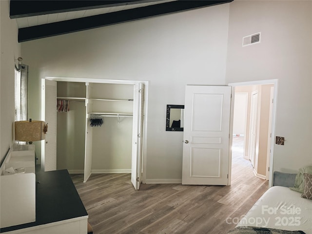 5017 Celeste Ct, Charlotte, NC 27609 - bedroom with wood finished floors, a closet, high vaulted ceiling, and beam ceiling