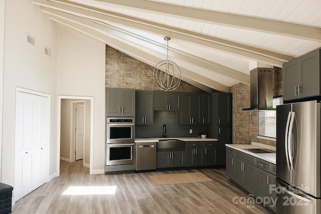 5017 Celeste Ct, Charlotte, NC 27609 - kitchen featuring appliances with stainless steel finishes, wall chimney range hood, light countertops, light wood-style flooring, and pendant lighting