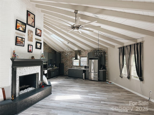 5017 Celeste Ct, Charlotte, NC 27609 - unfurnished living room with ceiling fan, light wood-type flooring, a fireplace with raised hearth, and a chandelier