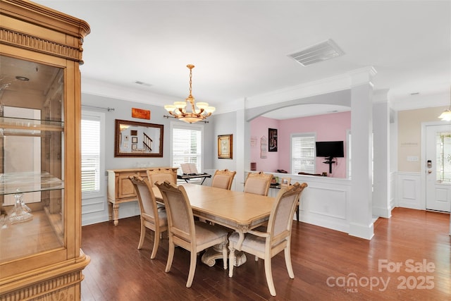 1636 Ridge Haven Rd, Waxhaw, NC 28173 - dining area featuring a chandelier, dark wood-style flooring, crown molding, arched walkways, and wainscoting