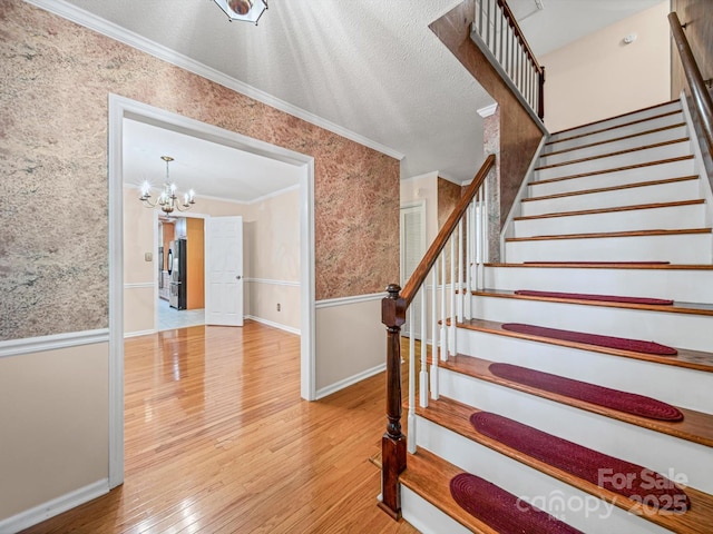 2020 Dawnshire Dr, Gastonia, NC 28054 - stairway featuring wallpapered walls, crown molding, a chandelier, hardwood / wood-style floors, and a textured ceiling