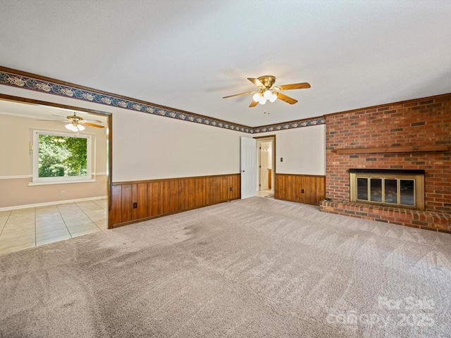 2020 Dawnshire Dr, Gastonia, NC 28054 - unfurnished living room featuring a ceiling fan, wainscoting, carpet, tile patterned floors, and a fireplace