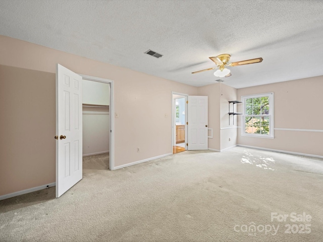 2020 Dawnshire Dr, Gastonia, NC 28054 - unfurnished bedroom with carpet floors, a textured ceiling, a spacious closet, ensuite bathroom, and a ceiling fan