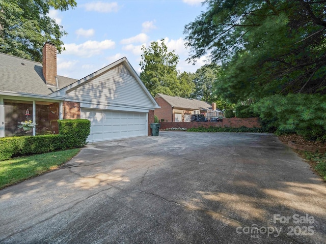 2020 Dawnshire Dr, Gastonia, NC 28054 - view of property exterior with driveway, a chimney, a garage, and brick siding