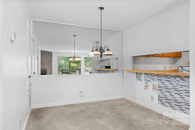1604 Sharon Rd W Unit 30, Charlotte, NC 28210 - kitchen with a chandelier, carpet floors, brown cabinetry, pendant lighting, and light countertops