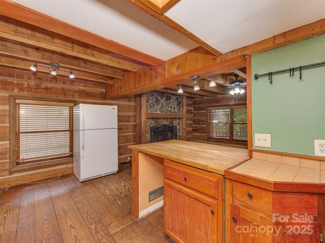 5109 Walnut Grove Ln, Charlotte, NC 28227 - kitchen featuring freestanding refrigerator, wood walls, wood-type flooring, beamed ceiling, and a fireplace