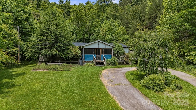 311 Flynn Br, Madison, NC 28753 - view of front of property featuring a front yard, a metal roof, a forest view, and asphalt driveway