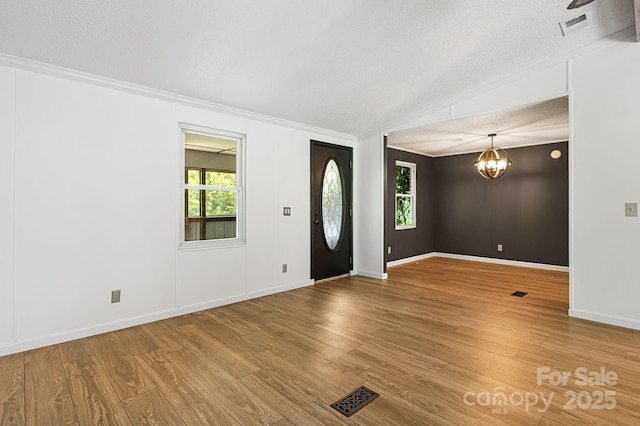 311 Flynn Br, Madison, NC 28753 - entryway with a textured ceiling, crown molding, a chandelier, and wood finished floors