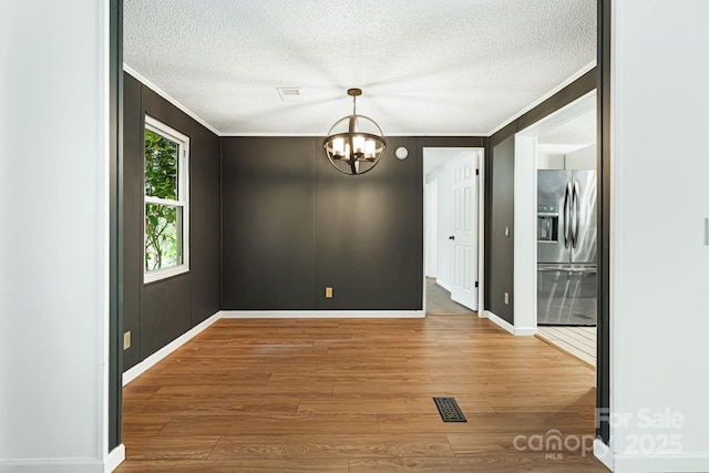 311 Flynn Br, Madison, NC 28753 - spare room featuring ornamental molding, a chandelier, wood finished floors, and a textured ceiling