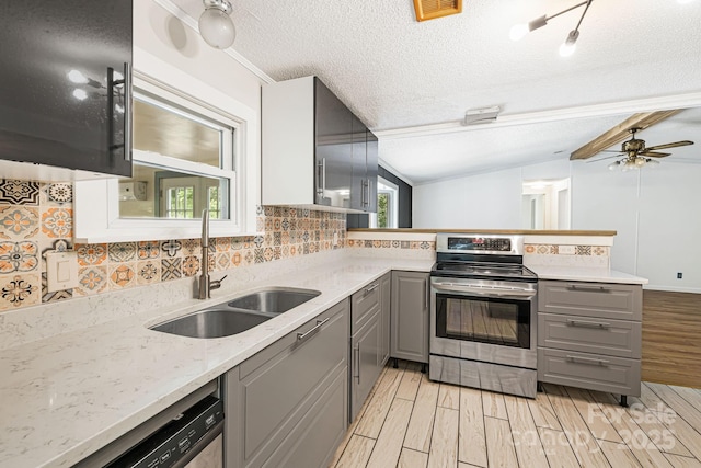 311 Flynn Br, Madison, NC 28753 - kitchen featuring gray cabinetry, stainless steel appliances, light wood-type flooring, decorative backsplash, and a peninsula
