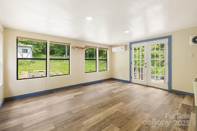 311 Flynn Br, Madison, NC 28753 - empty room with wood finished floors, a wall mounted air conditioner, healthy amount of natural light, and recessed lighting