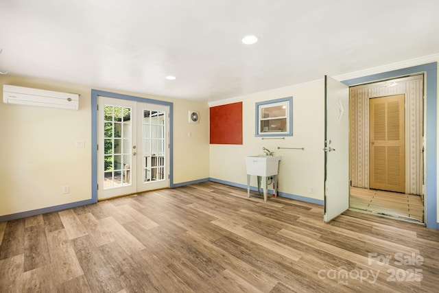 311 Flynn Br, Madison, NC 28753 - unfurnished living room featuring a wall mounted air conditioner, wood finished floors, french doors, crown molding, and recessed lighting