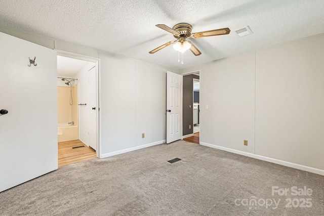 311 Flynn Br, Madison, NC 28753 - unfurnished bedroom featuring carpet flooring, a textured ceiling, connected bathroom, and ceiling fan