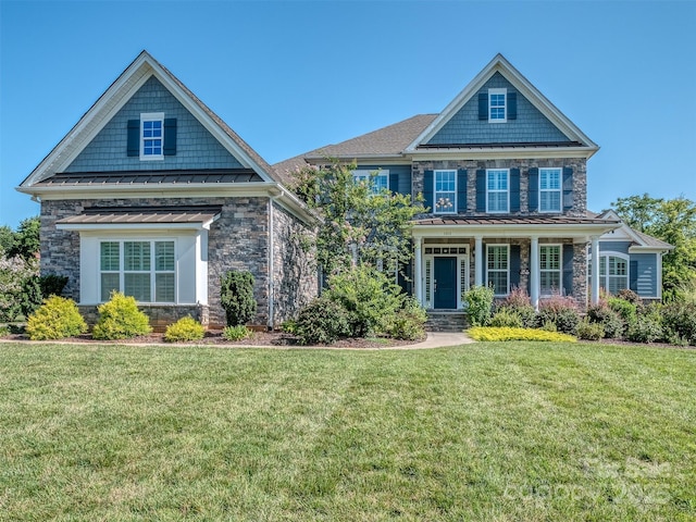 1011 Golden Bell Dr, Waxhaw, NC 28173 - craftsman house with a standing seam roof, stone siding, a metal roof, a front yard, and covered porch